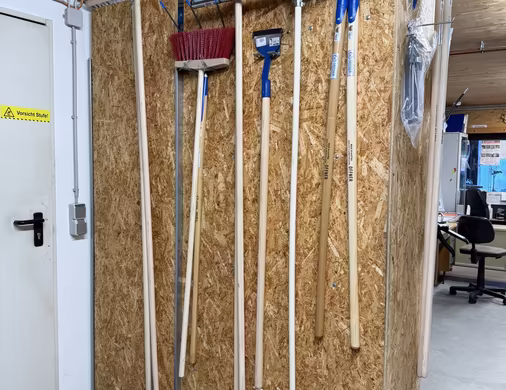 Umfangreiches Sortiment an Baumaterialien und Baustoffen, mit Besen, Rechen, Mistgabeln, Wasserschieber